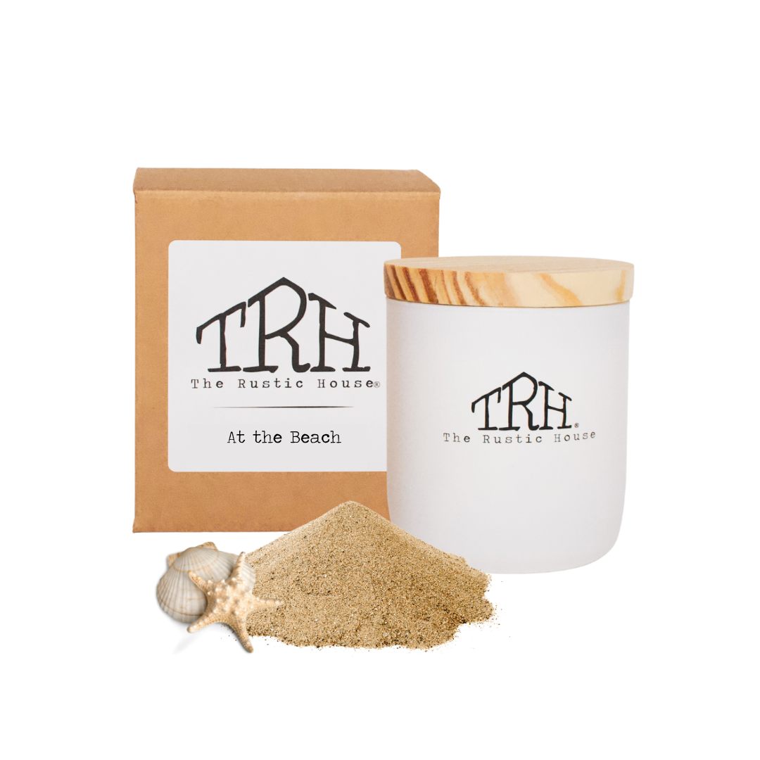 At the Beach glass candle with its gift box and a mound of sand